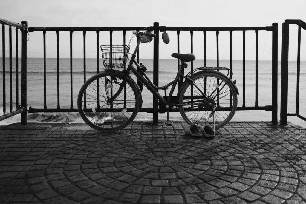 Vélo garé contre une balustrade à côté de chaussures en noir et blanc